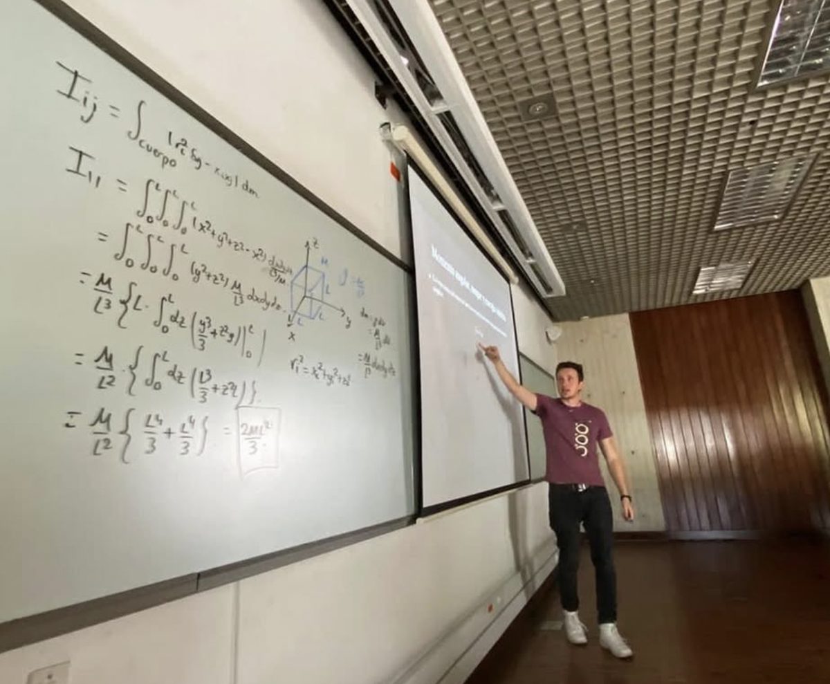 Juan José Mejía explicando el desarrollo del tensor de inercia en un tablero durante el seminario