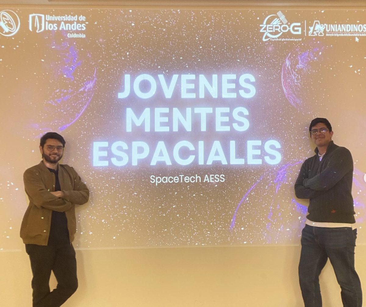Dos integrantes del capítulo frente a la diapositiva de apertura de Jóvenes Mentes Espaciales