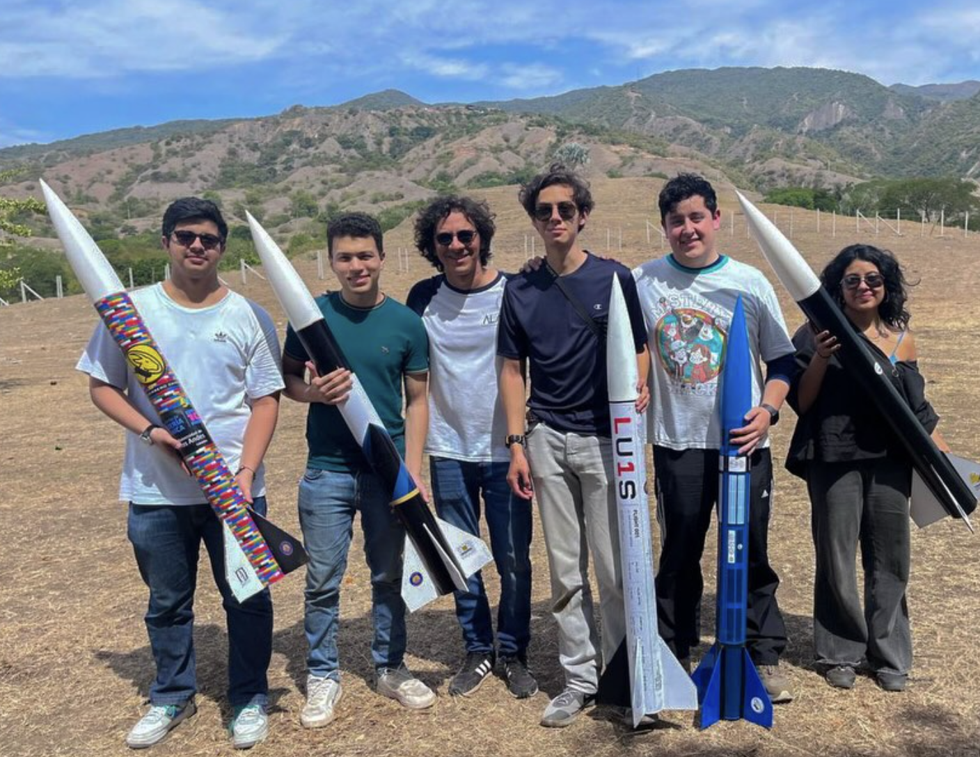 Integrantes de la División de Cohetería con sus cohetes en el campo de lanzamiento